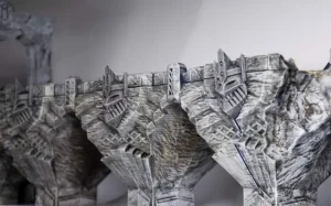 Side view of the 3D printed modular bridge from the Mines of Maznar terrain set, showing stonework details, fully painted for tabletop gaming